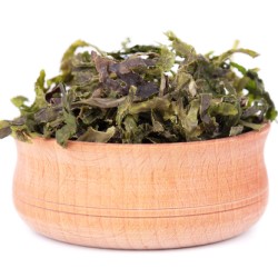 Dry wakame seaweed in wooden bowl, isolated on white background. Sea kale, asian dry food